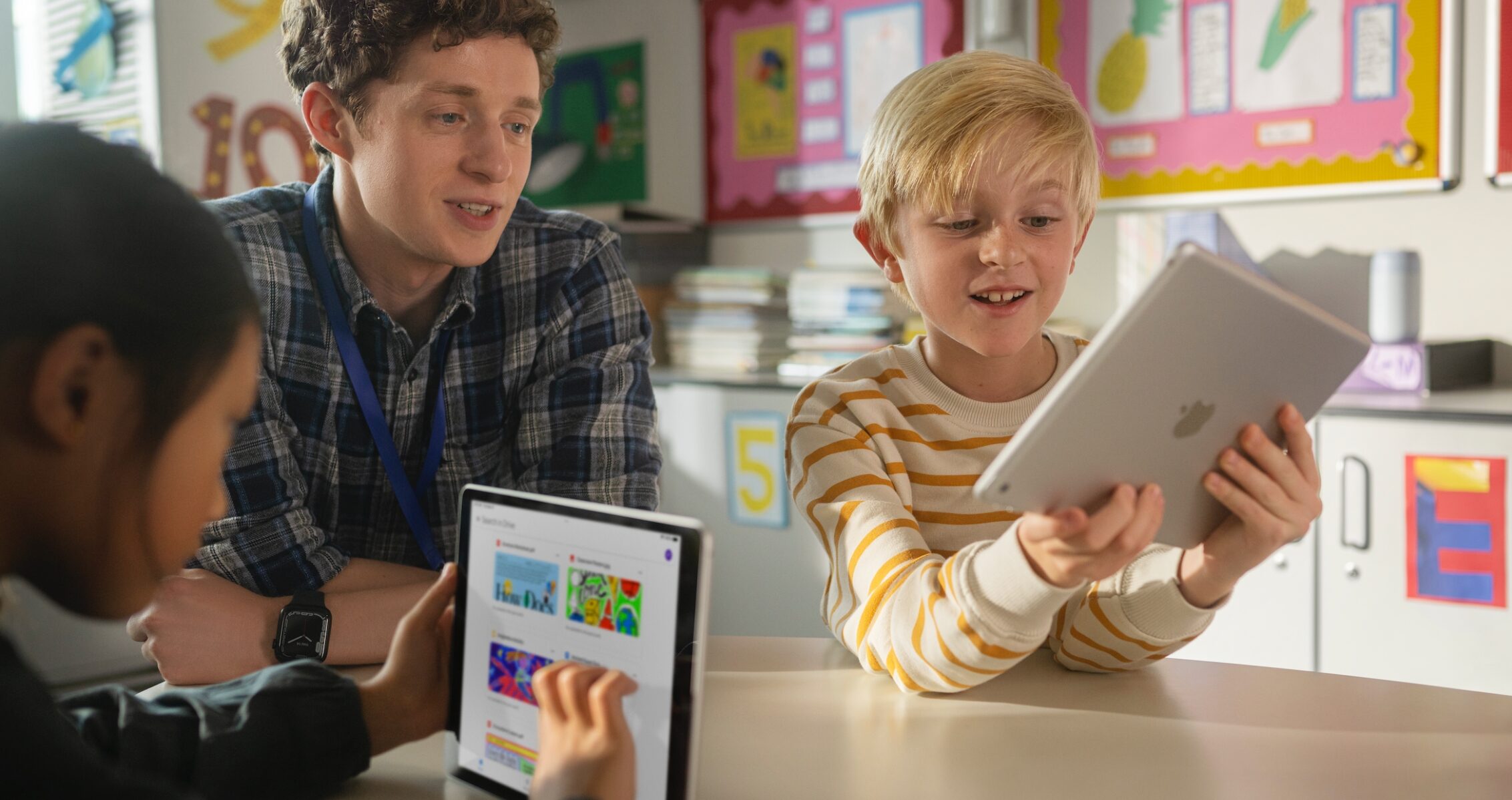 Teacher supporting students with iPad