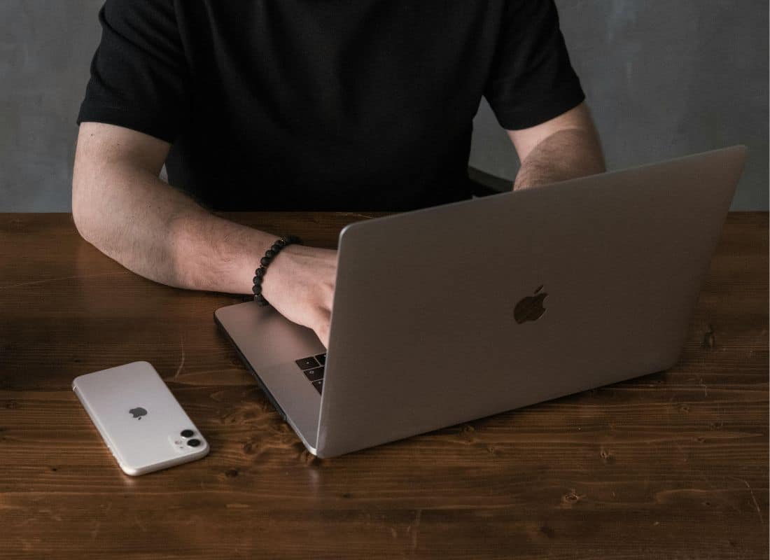 A Government worker using Mac and iPhone to complete their work.