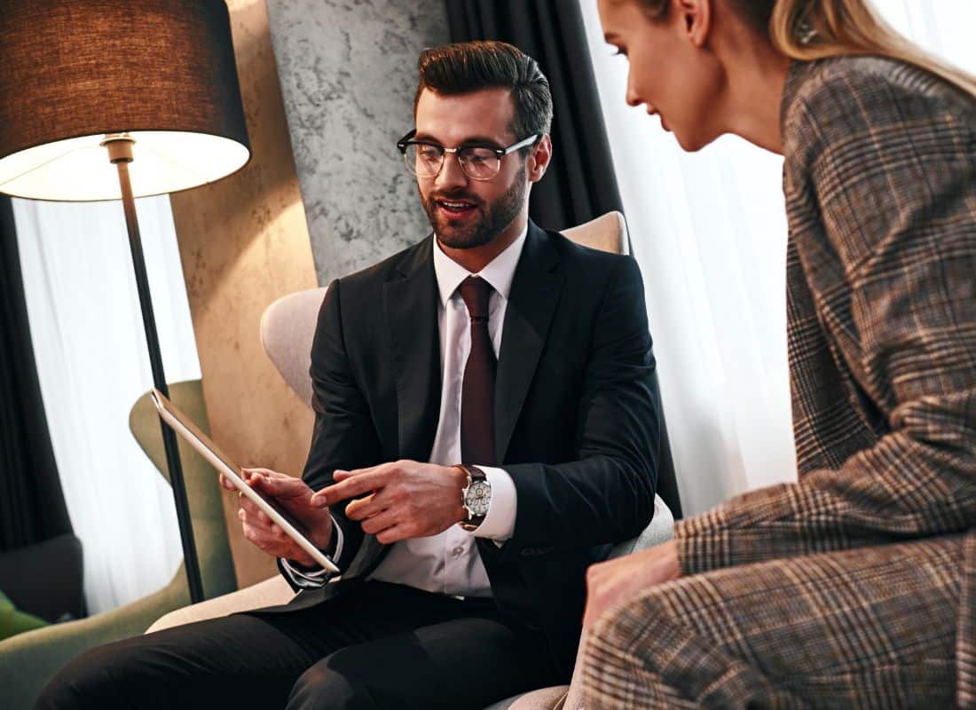 Two government workers using an iPad to assess budgets.