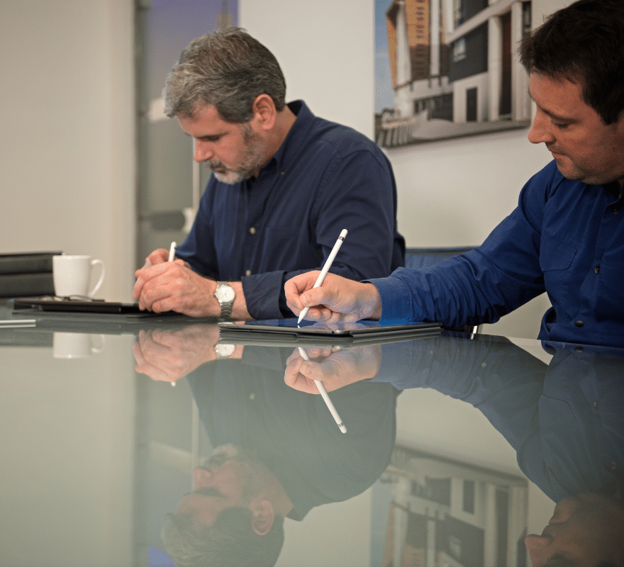 Two men writing notes using iPad & Apple Pencil